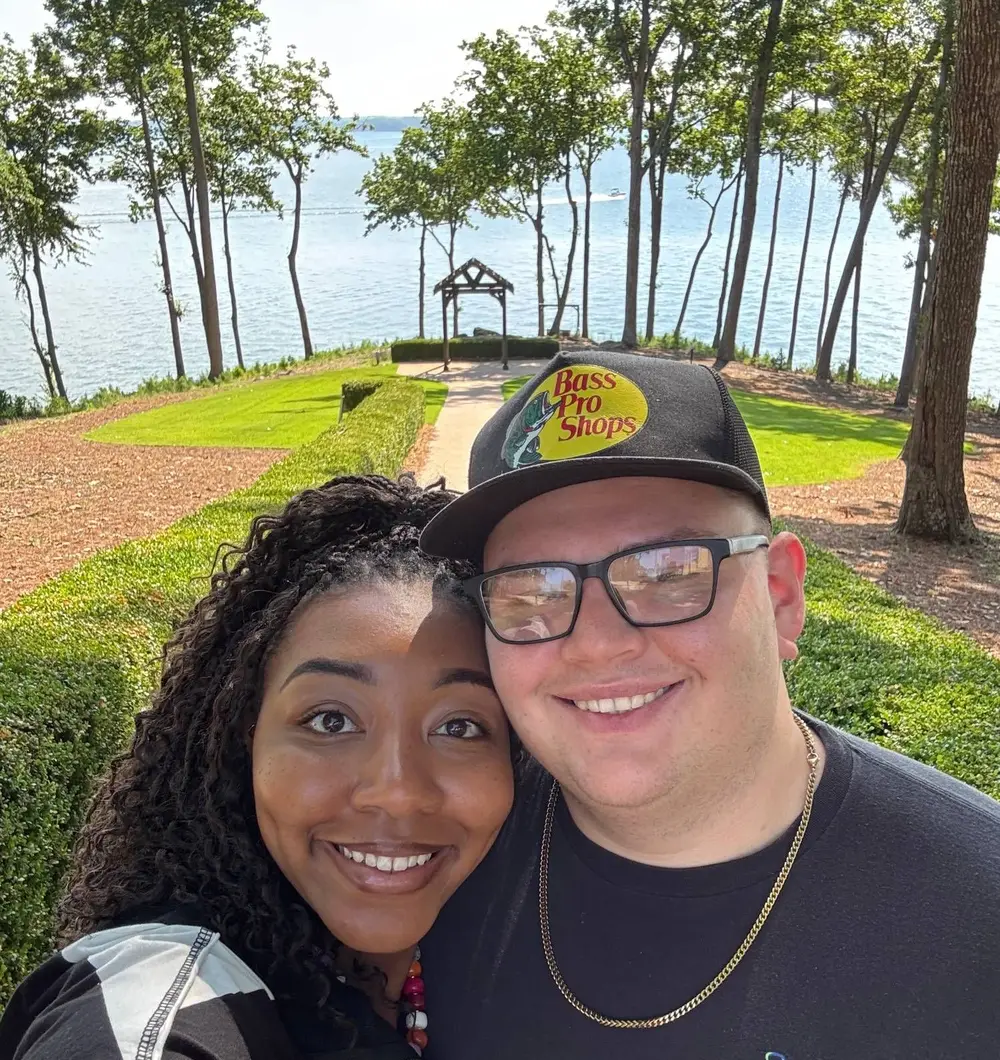 Stone Merton and his wife, Devonna, smiling together on a lakeside walk